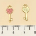 Pink glitter heart-shaped key charm with gold metal frame and striped back detail - Pink Glitter Enamel Key (21491) / 16x7mm