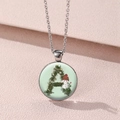 Close-up of glass pendant necklace featuring green letter A and small snowman illustration - Letter A With Snowman (Style 6)