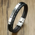 Nahaufnahme der Edelstahlschließe und gravierter GOD IS FIRST Spruch auf Lederarmband - Silber