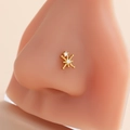 Golden stainless steel nose stud with star design and clear zircon stones on a model - Starburst Snowflake Style (9#) / Gold
