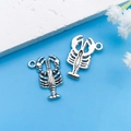 Silver lobster-shaped charms for jewelry making on light blue background - Antique Silver Ocean Lobster 16x22mm