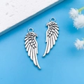 Silver alloy feather pendants for DIY jewelry making on a blue background - Antique Silver Eagle Wings Style (8988)