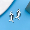 Pair of antique silver fish bone charms for DIY jewelry making on blue background - Fish Bone Style (6682)