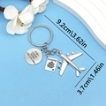 Silver travel keychain with airplane and passport charms on a light blue background - Plane Passport Everyjourney Tag (ER681)