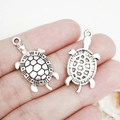 Macro shot of two vintage silver turtle charms showing front and back detail for DIY jewelry - Antique Silver Turtle (15.5x30mm-18808)