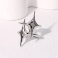 Makroaufnahme eines polierten silbernen asymmetrischen Sternenrings mit Glanzfinish - Stahlfarben