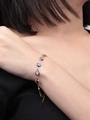 Detalle de la pulsera de ojo turco con cuentas de esmalte azul en cadena dorada - Pulsera Azul