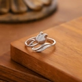 Primer plano de un anillo de tulipán plateado con hojas estilizadas en fondo madera - Estilo Tulipán (40242) / Plateado