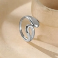 Detail of a silver liquid-metal style ring on a textured beige ceramic bowl edge - Silver