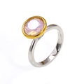 Detailed close-up of a two-tone 18k gold ring with a sparkling pink round-cut zircon - Two-tone Gold Opal Pink Zirconia