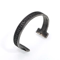 Detailed macro view of vintage silver Viking Futhark runes engraved on an open cuff bracelet - Antique Silver