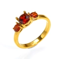 Dettaglio anello in titanio placcato oro 18k con tre zirconi rossi tondi incastonati - US 6 / Oro Zirconia Rossa