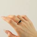 Detail van een elegante 18k vergulde ring met drie fonkelende blauwe zirkonia steentjes - Goudkleur Zwarte Strass
