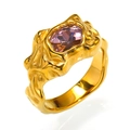 Makro-Detail des goldenen Lavaringes mit einem funkelnden lila Edelstein - Gold Rosa Zirkonia