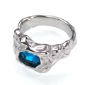 Nahaufnahme eines silbernen Rings mit Faltenoptik und einem großen ovalen blauen Edelstein - Silberne Farbe Saphirblauer Edelstein