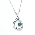 Macro-detail van de zilveren ketting met een druppelvormige hanger en groene edelsteen - Zilver Groene Edelsteen