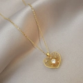 Collar con colgante de corazón dorado, textura de rayos de sol y circón sobre seda - Estilo Corazón