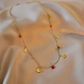 Detail of gold butterfly necklace with colorful beads on champagne satin background - Gold