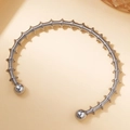 Detalle de brazalete rígido de acero inoxidable plateado con textura de resorte espiral - Latido de tambor #2 / Plateado