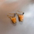 Close-up of miniature milk tea cup earrings with gold hooks and clear crystal studs - Orange