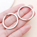 Two flat silver metal key rings held by hand for DIY jewelry and bag accessories - 30x30mm / White Gold