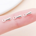 Silver teardrop jewelry charms shown on fingertips to illustrate the small 7x2.5mm size - 7x2.5mm / Bright Silver