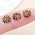 Calottes fleurs en bronze antique pour bijoux DIY présentées sur le bout d'un doigt - 7mm / Bronze Antique