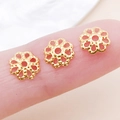 Calottes de perles dorées en fer ajouré pour bijoux DIY posées sur le bout du doigt - 7mm / Or