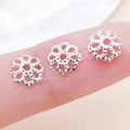Calottes de fleurs creuses en argent pour bijoux DIY présentées sur le doigt - 7mm / Argent Brillant