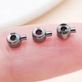 Three gun-black copper crimp beads for jewelry making shown on a fingertip for scale - Flat / 4.5x3mm Hole 1mm / Gunmetal