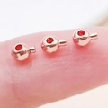 Three rose gold round slider beads with red dots on finger showing miniature scale size - Round / 4.7x3.5mm Hole 1mm / Rose Gold