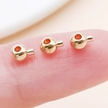 Golden round copper spacer beads for jewelry DIY held on a fingertip for scale - Round / 4.7x3.5mm Hole 1mm / KC Gold