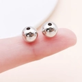 Pair of polished silver CCB spacer beads for DIY jewelry making shown on a fingertip - Round (14077) / 1 Piece/Pack (8mm) / White Gold