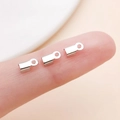 Three silver-colored iron cord ends and jewelry clasps shown for size on a fingertip - Small / White K Polished Style