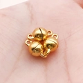 Trois fermoirs magnétiques ronds dorés pour bijoux DIY tenus dans la paume de la main - Petite Sphère Dorée Lisse