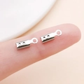 Silver metal crimp end cap with loop for jewelry making held on fingertip for size - White K Large Style with Points