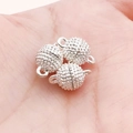 Fermoir magnétique sphérique en argent avec effet stardust montré dans la main - Petite Sphère Argentée Dépolie