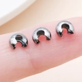 Gunmetal grey C-shaped crimp covers for jewelry making shown on fingertips - Gun Black - Medium