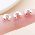 Silver crimp bead covers for jewelry making shown on fingertips for size comparison - Silver - Large