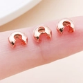 Rose gold copper crescent bead covers for DIY jewelry making shown on fingertips - Rose Gold-Large