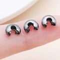 Three gunmetal grey crescent bead covers on a finger showing the small scale for DIY jewelry - Gun Black - Large