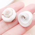 Natural white spiral sea shell pendant charms on fingertips for DIY jewelry making - Drilled Spiral Tail Creamy White Conch Spacer Bead