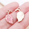 Pink and gold enamel leaf charm pendant for DIY jewelry making shown in hand - 9.5x19.5mm / Rose Red Plant Leaf (17570)