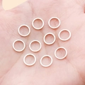 Set of ten silver-colored flat metal rings for DIY jewelry making in palm view - 8mm / Bright Silver
