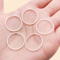 Set of five minimalist silver geometric thin round rings shown on a hand model - 20mm / Bright Silver