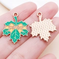 Green enamel maple leaf pendant with golden bow detail and rose gold textured back - 25x20MM / Green Bow Maple Leaf (25232)