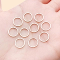 Set of 10 rose gold copper round ring connectors for DIY jewelry making held in palm - 10mm / White Gold