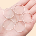 Set of 5 minimalist silver copper geometric rings held in palm for size reference - 25mm / White Gold
