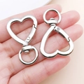Silver heart-shaped spring clip keychain accessory shown in hand for size comparison - Silver Heart Clasp (42x26x5mm)