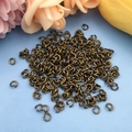 Dettaglio di anellini aperti in bronzo antico per creazione di gioielli fai-da-te - 8x1.2mm / Bronzo